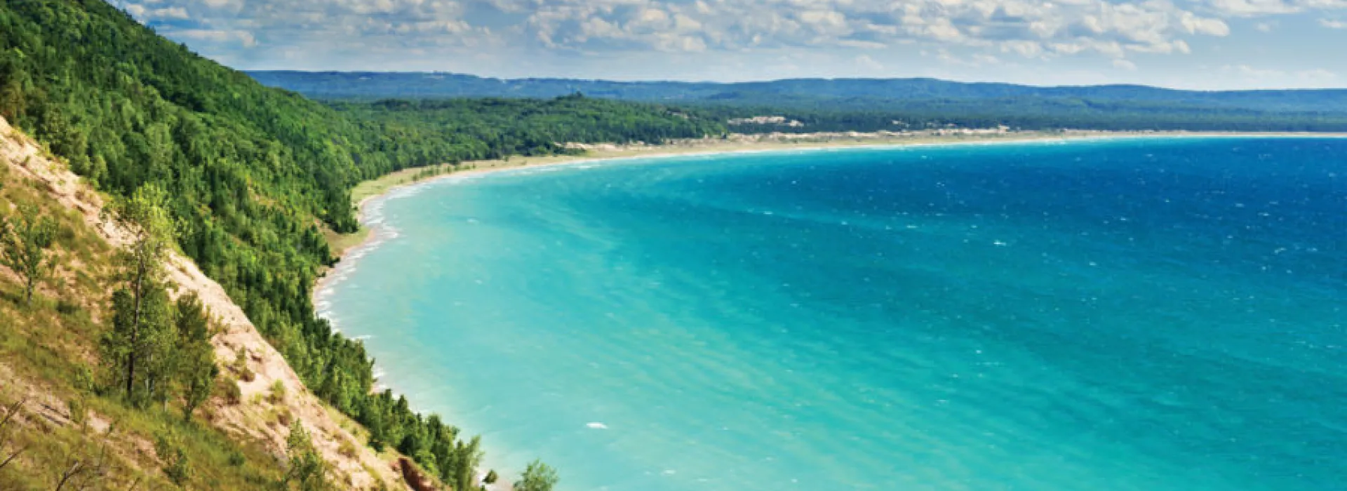 Sweeping view of lake meeting the shore of Sleeping Bear Dunes