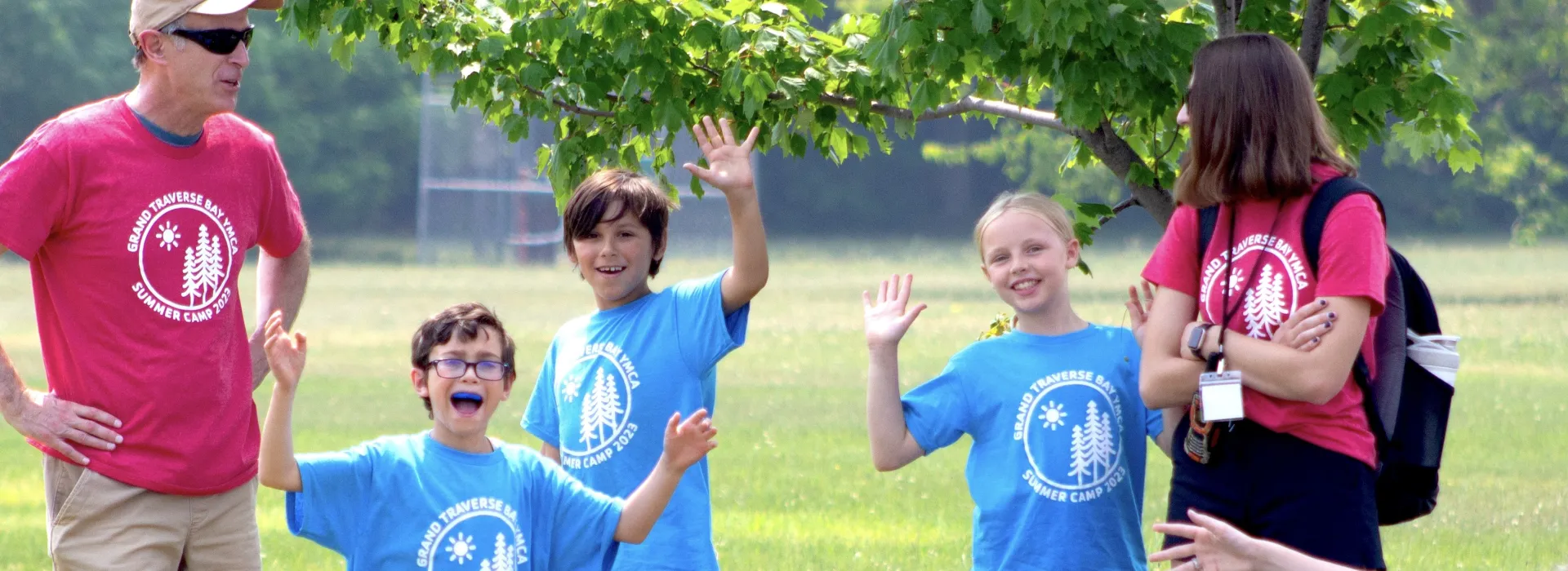 YMCA Summer Camp instructors and students spend time outside.