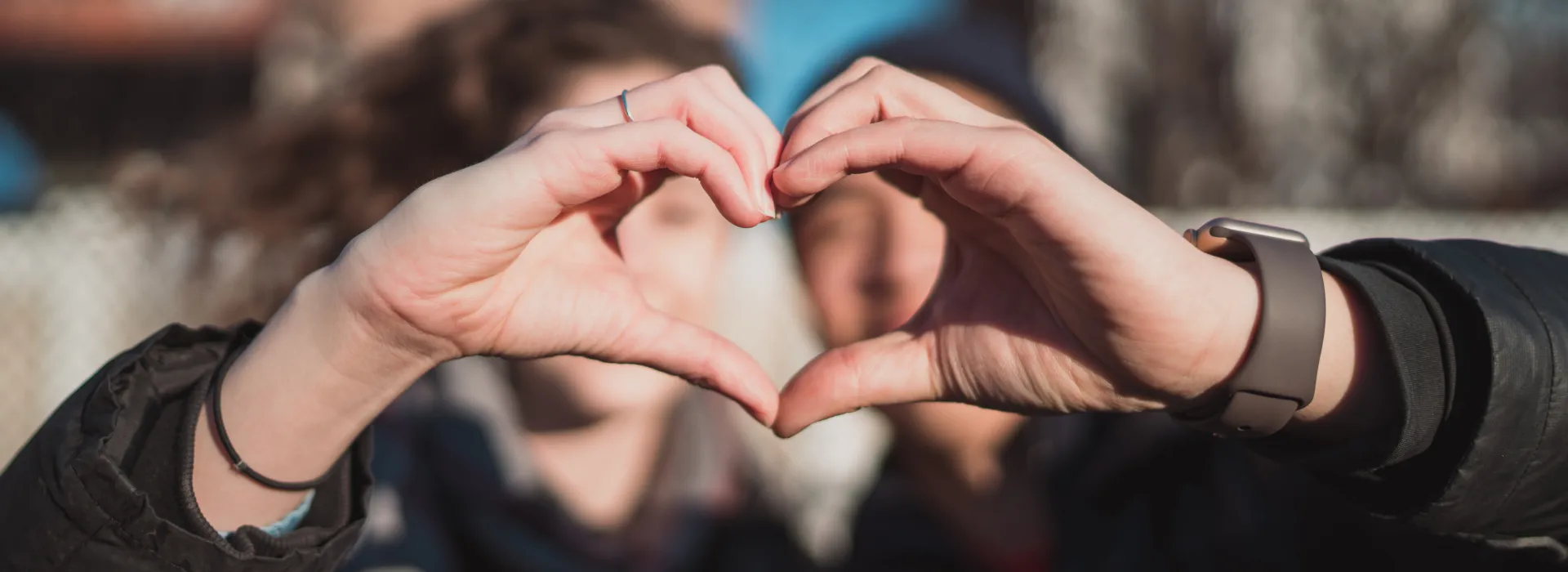 Close up of two peoples' hands held together to form a heart.