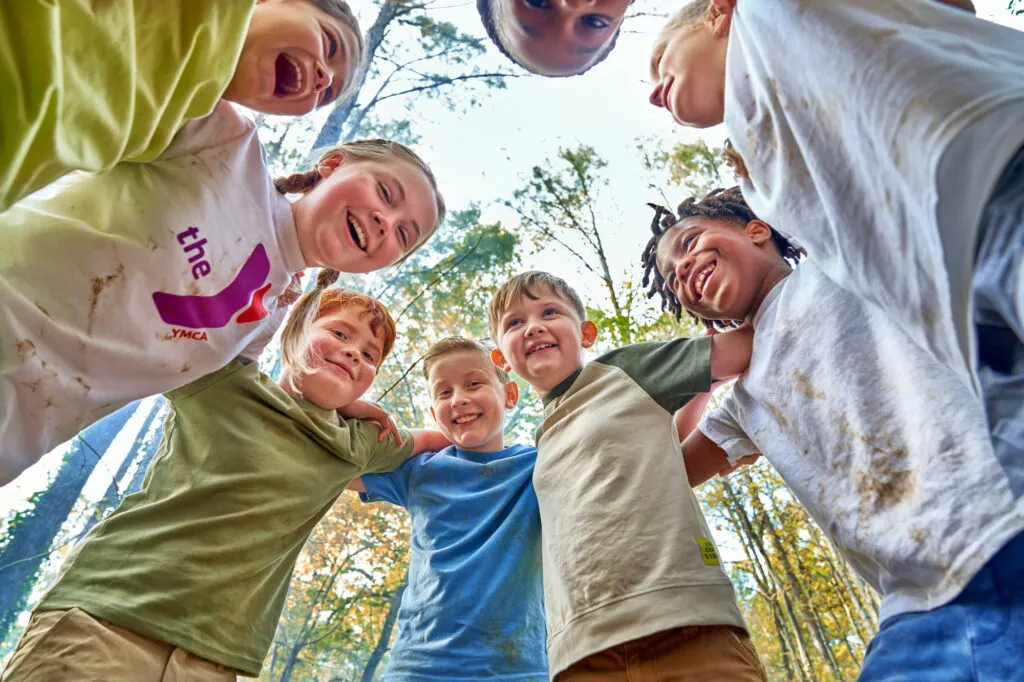 Children in Y apparel huddle in a circle