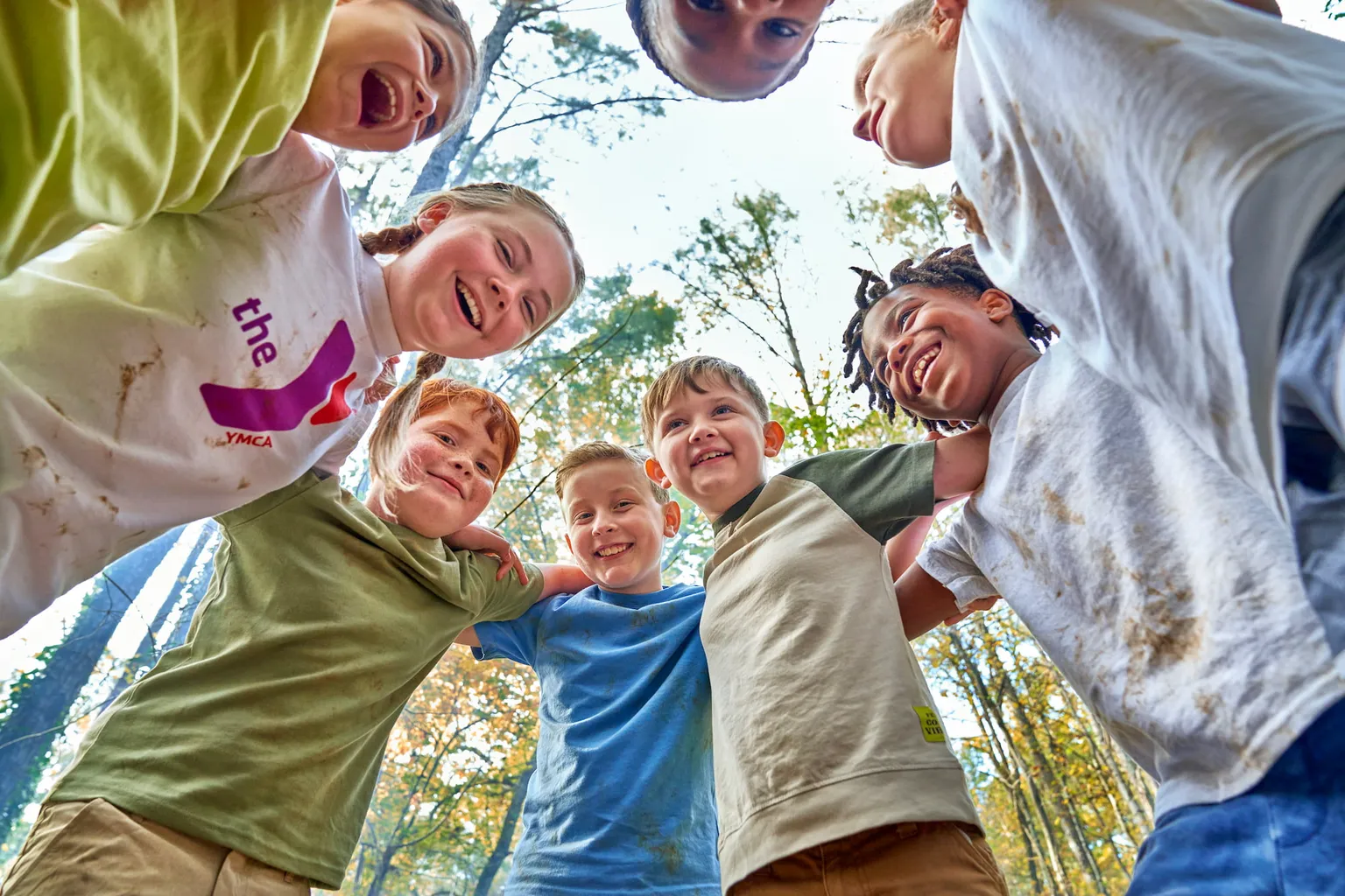 Children in Y apparel huddle in a circle