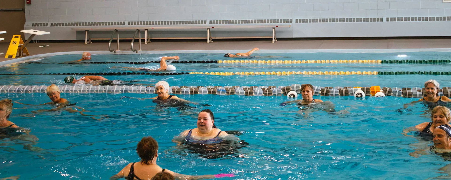 Aqua fitness class in progress with other swimmers doing laps in the background
