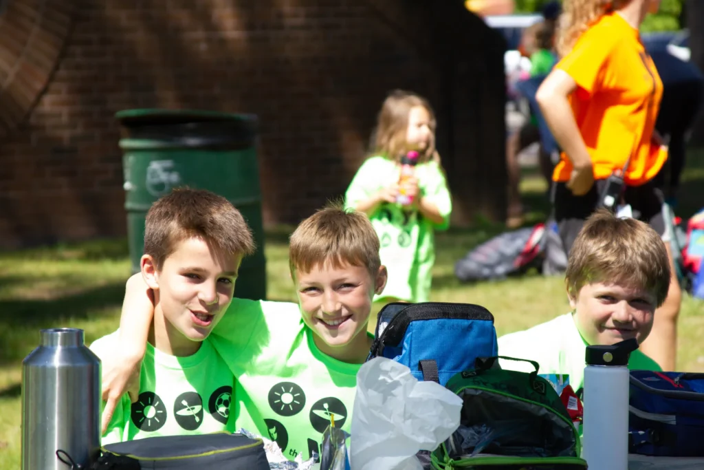 Campers sit together at an outdoor lunch table