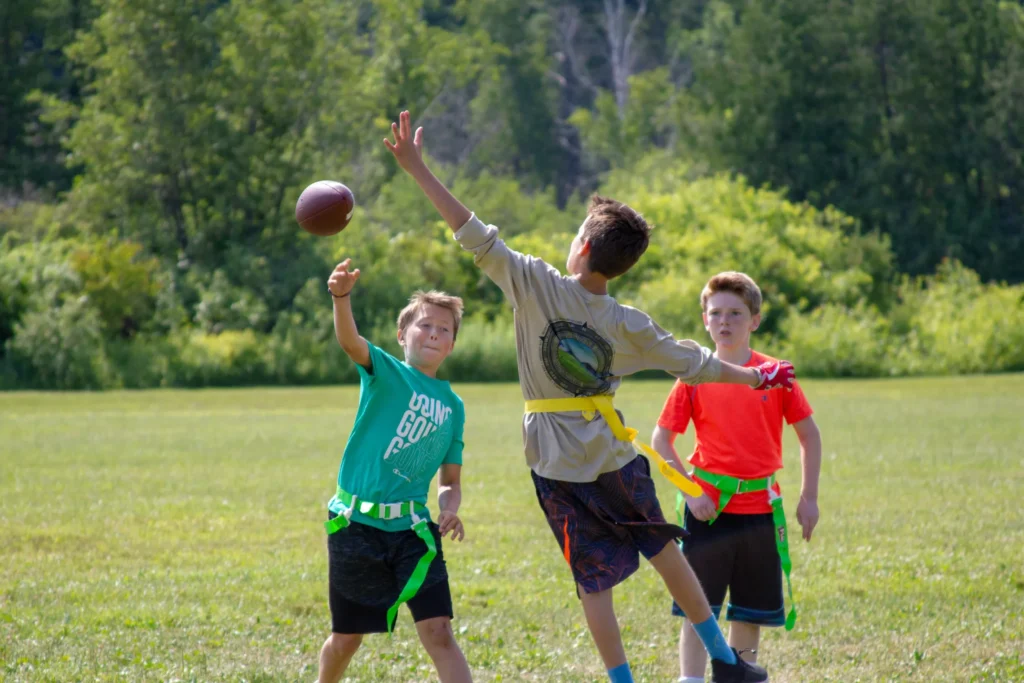 A camper leaps to capture the ball in a game of flag football