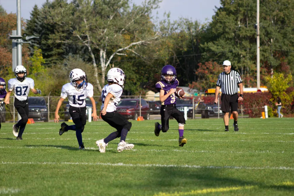 Youth footballers run across the field