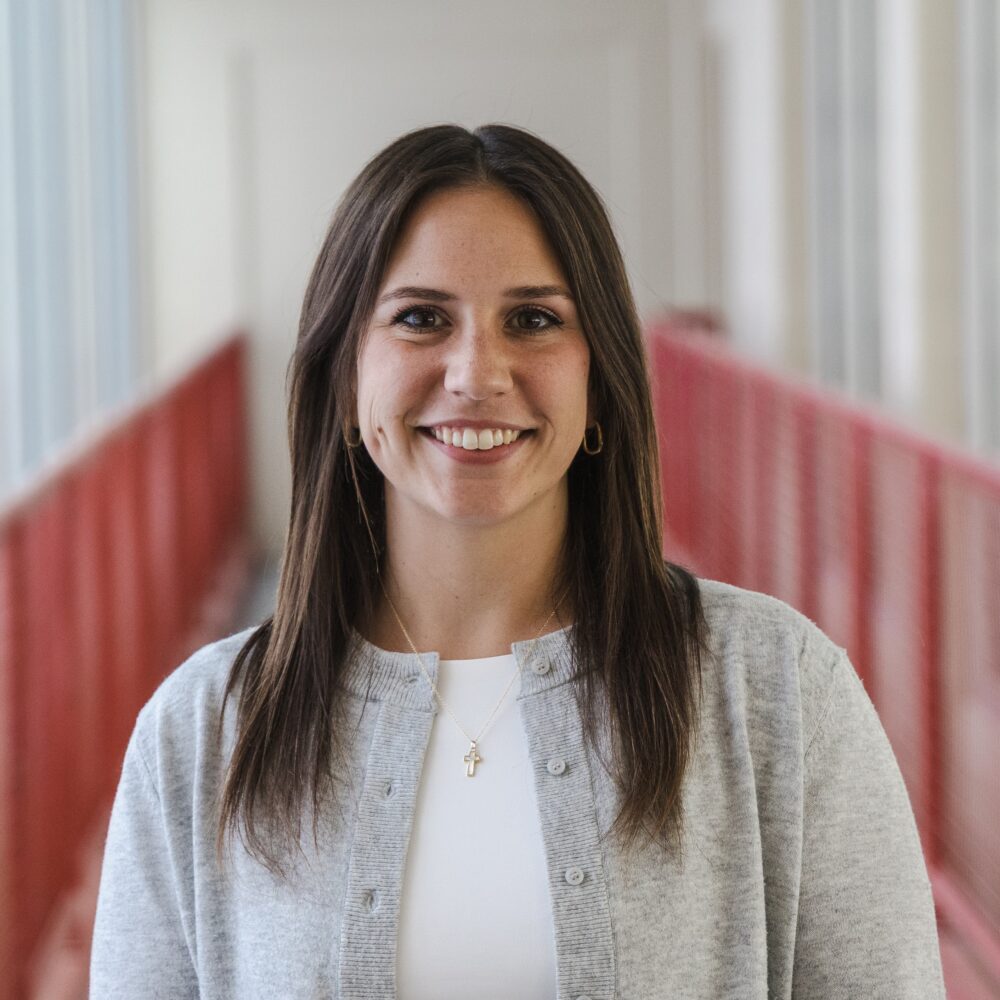 Smiling young woman with brown hair and warm eyes.